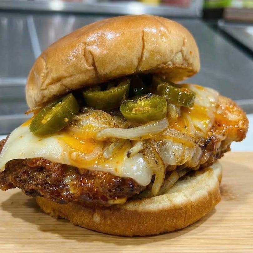 Checkmate Burgers' spicy chicken sandwich with melted cheese, caramelized onions, and jalapeños.